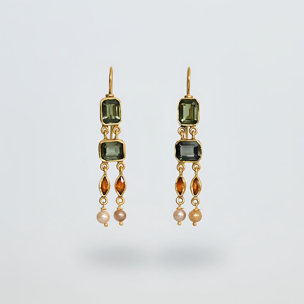 Pair of gold plated silver earrings with green gemstones on a light gray background