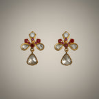 Pair of gold plated silver earrings with gemstones on a beige background