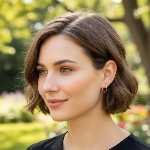 Close-up of a woman wearing an accent bead Bali silver hoop earring in a park