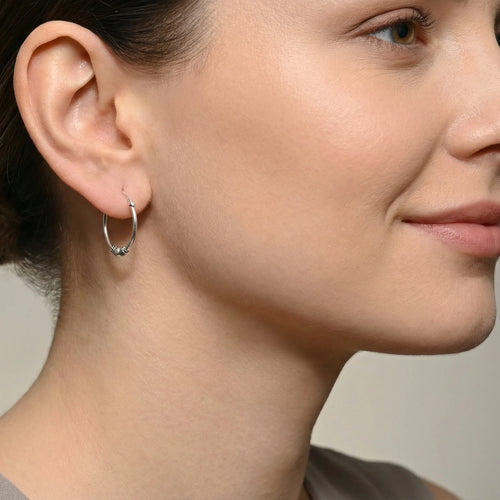 Close-up of a woman wearing an accent bead Bali silver hoop earring