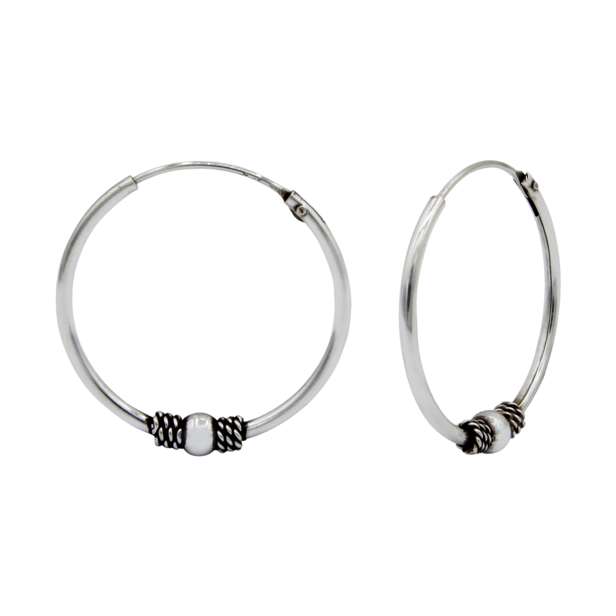 Pair of oxidized silver Bali hoop earrings with bead accents on a white background