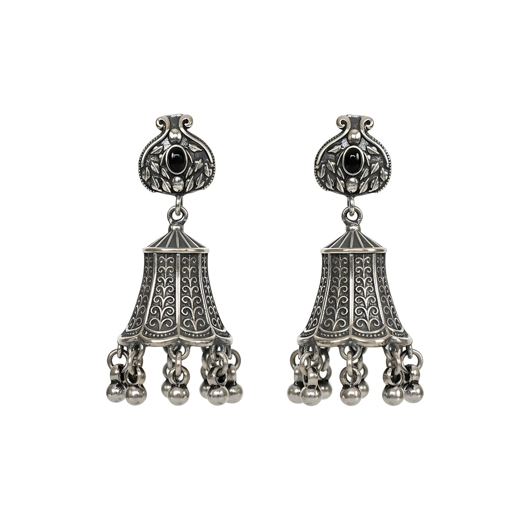 Pair of oxidized silver jhumka earrings with black gemstones on a white background
