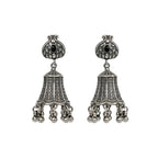 Pair of oxidized silver jhumka earrings with black gemstones on a white background