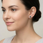 Close-up of a woman wearing a pair of 3 dome shaped oxidized silver earring with a neutral background