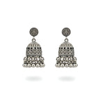 Pair of small oxidized silver jhumka earrings on a white background