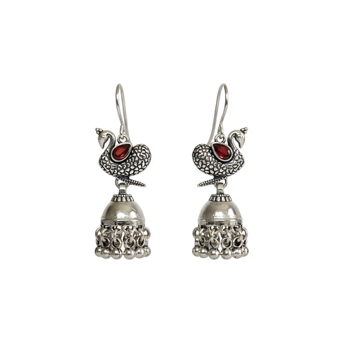 Pair of oxidized silver peacock  jhumka earrings with red gemstones on a white background