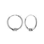 Pair of triple band Bali silver hoop earrings on a white background