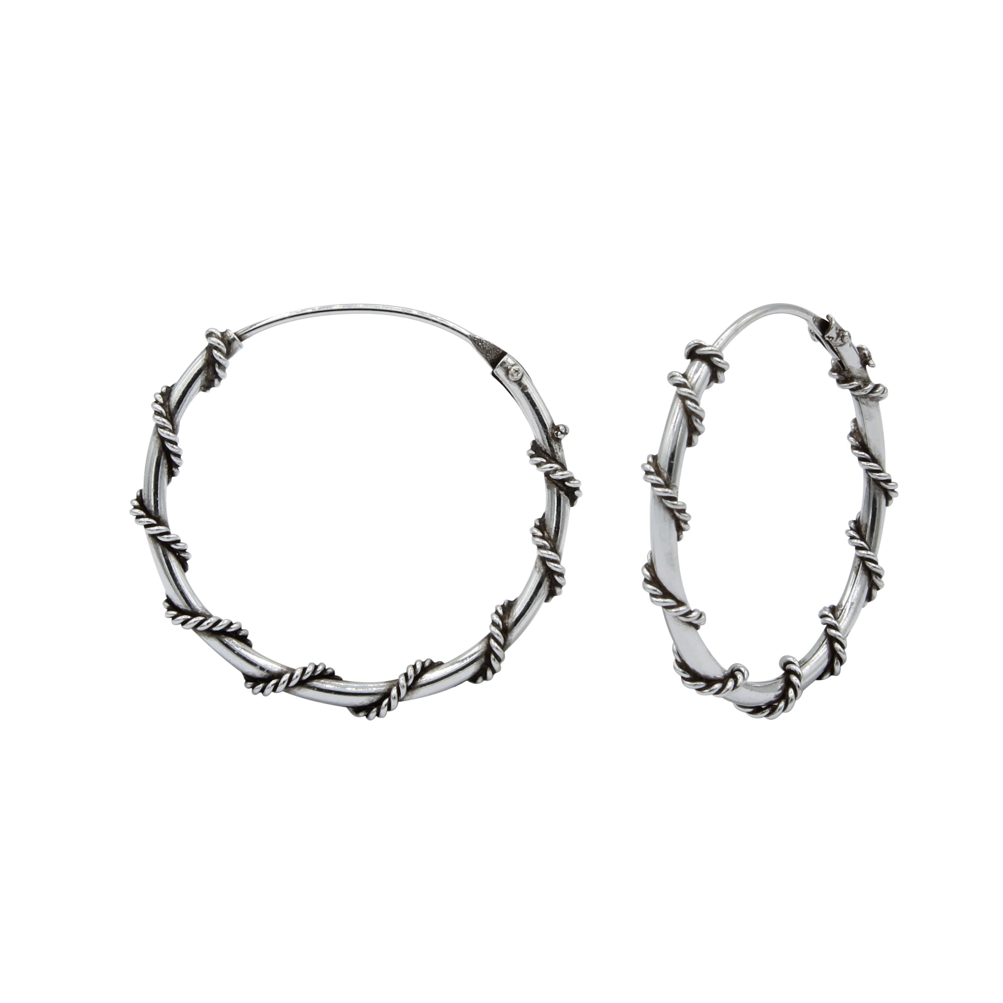 Pair of oxidized silver twisted Bali hoop earrings on a white background