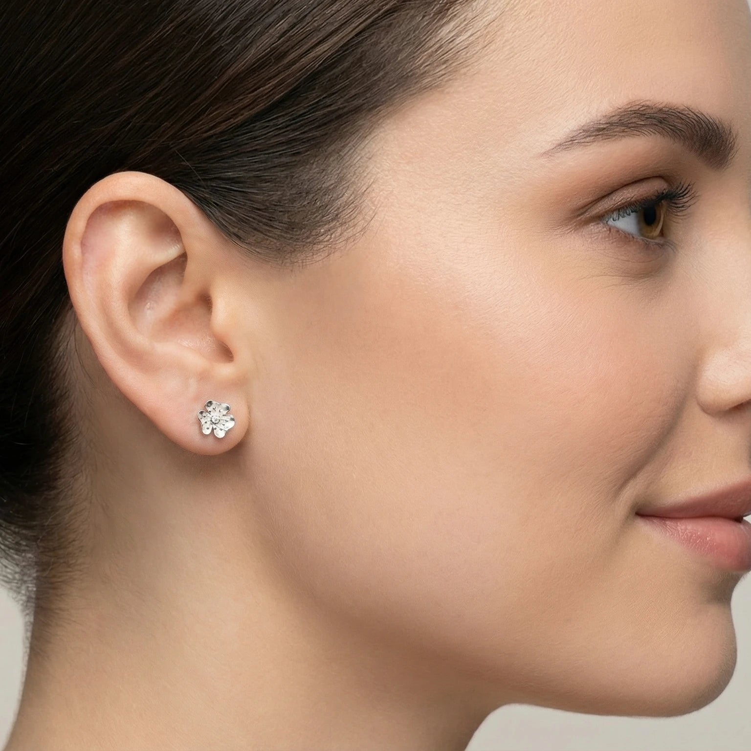 Closeup of a woman wearing a CZ flower stud earring