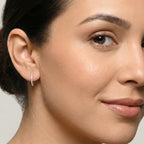 Close-up of a woman wearing Silver CZ French Lock Hoop Earrings against a neutral background
