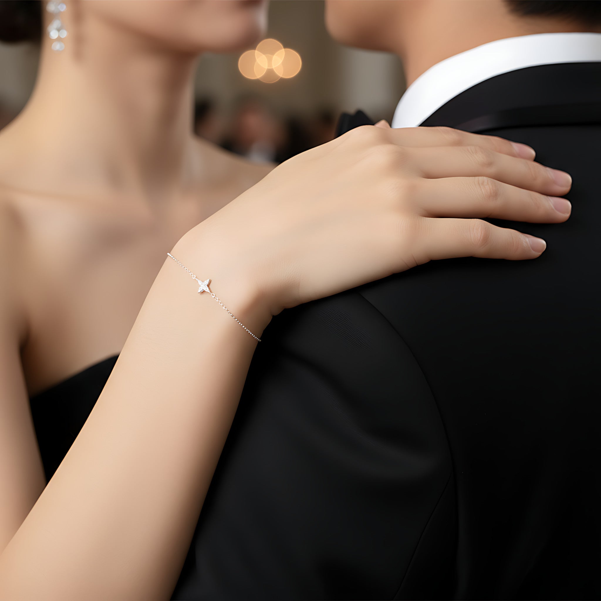 A couple dancing and the woman wearing a delicate silver star bracelet with a blurred background