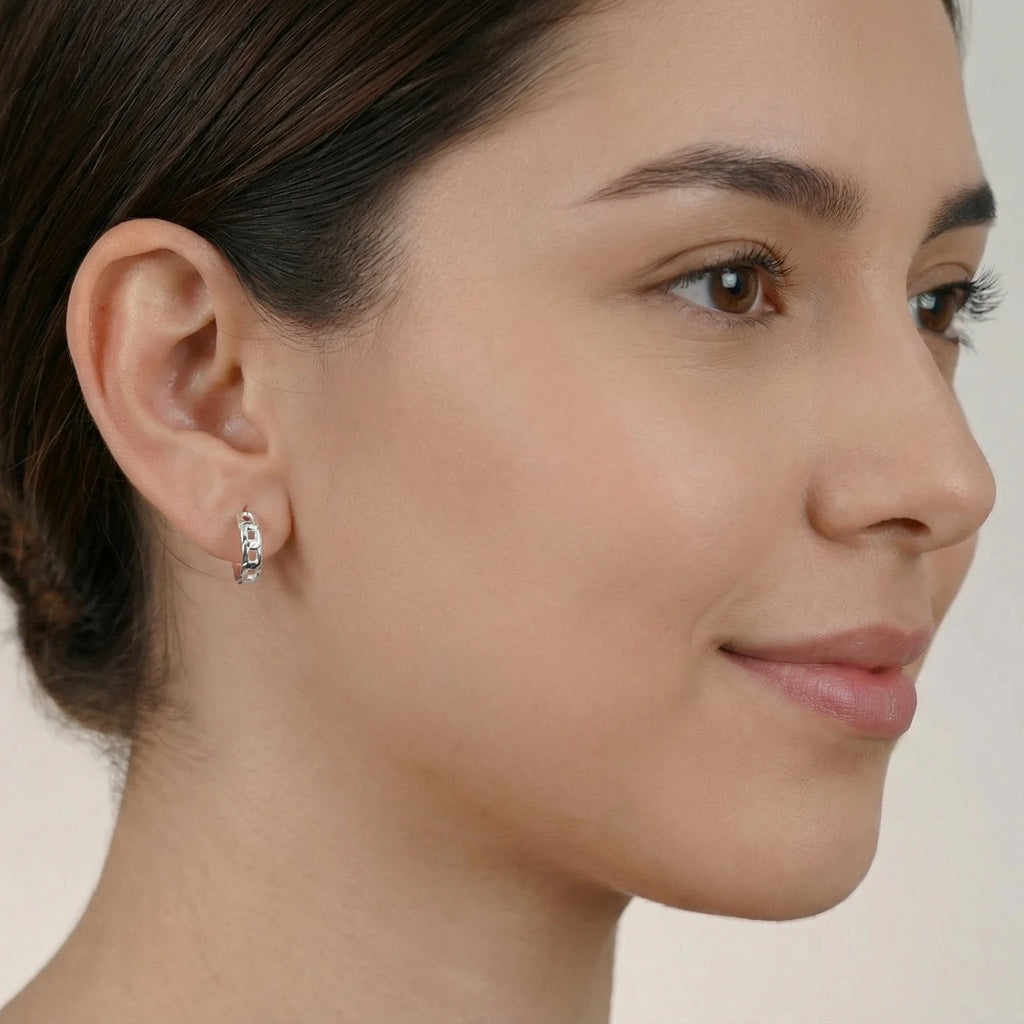 Close-up of a female wearing a silver chain link half hoop stud earring with a neutral background