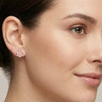 Closeup of a woman with a neat hairstyle wearing a circle shaped silver stud earring.