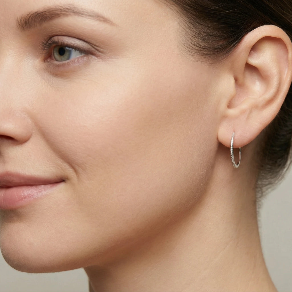 Closeup of a woman wearing diamond cut hoop earring
