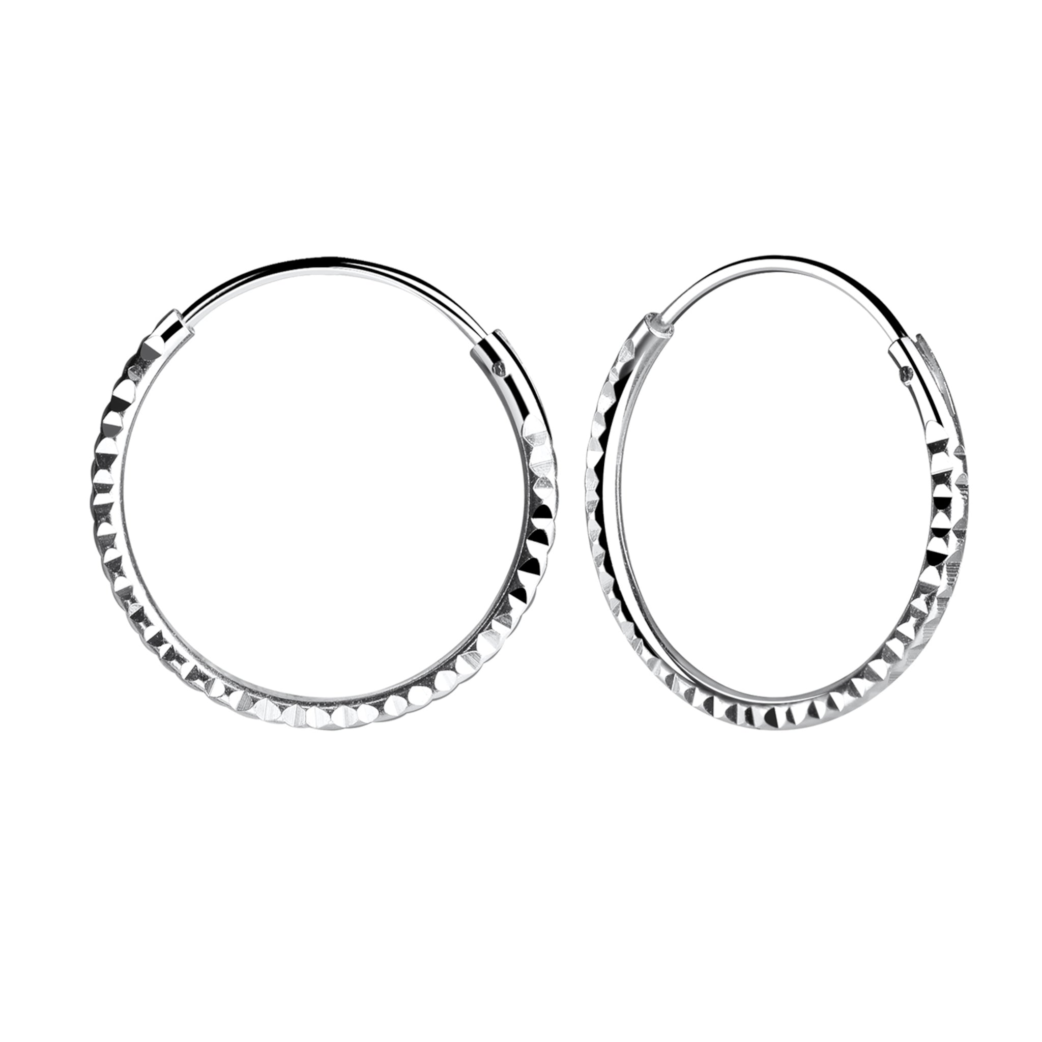 Pair of diamond cut silver hoop earrings on a white background