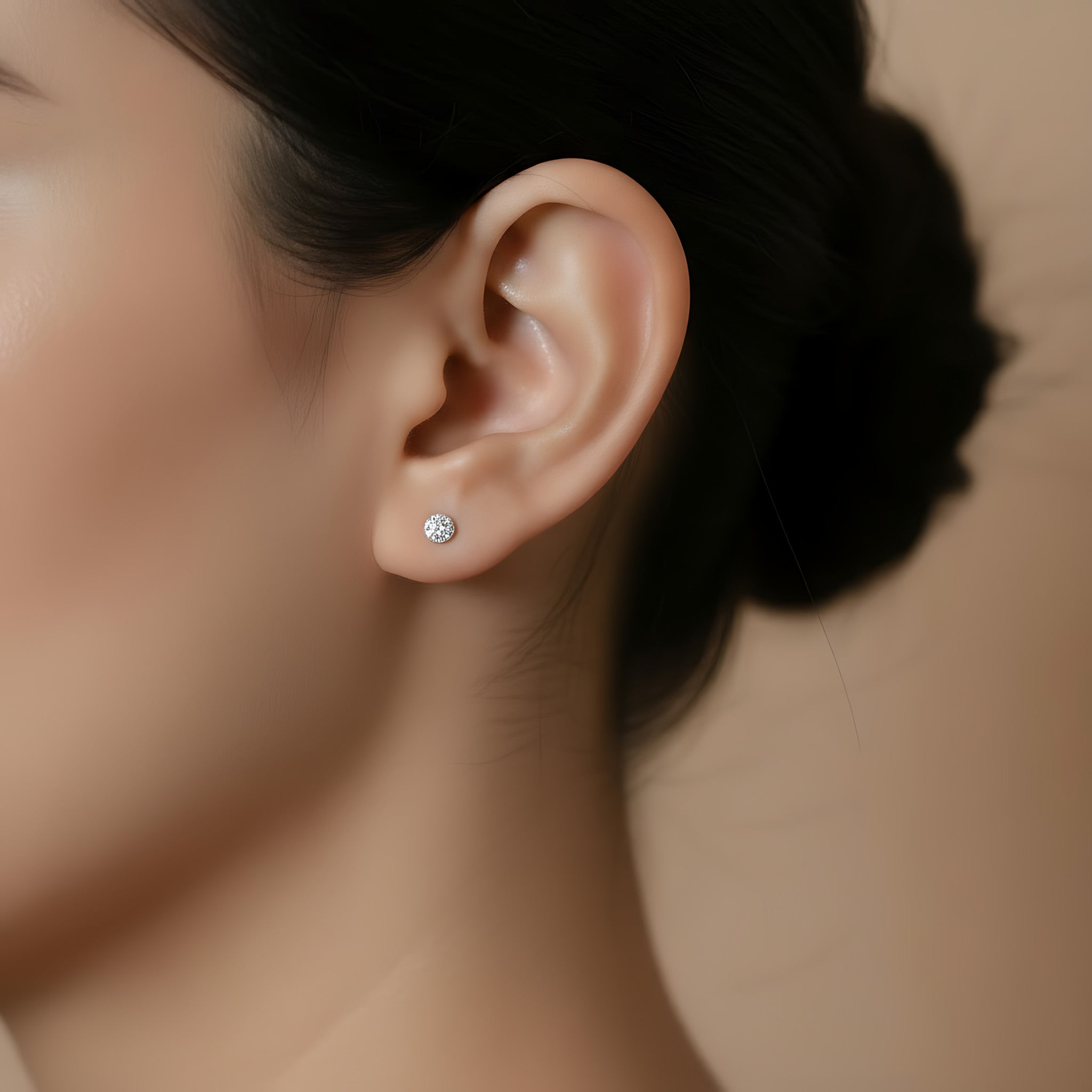 Close-up of an ear wearing a diamond dusted ball stud earring with a blurred background