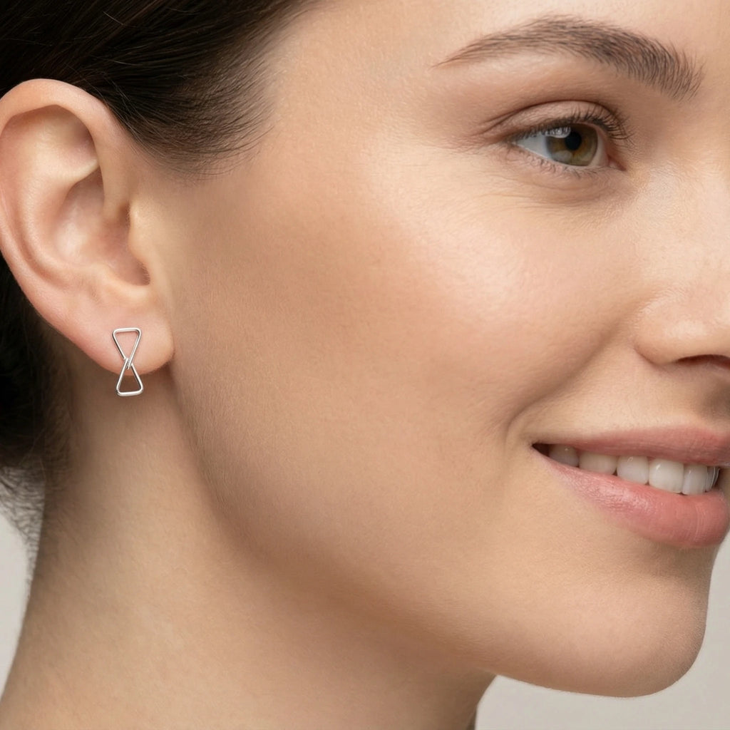Close-up of a woman wearing a silver double triangle earring