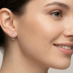 Close-up of a woman wearing a silver double triangle earring