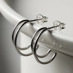 Silver half hoop stud earrings on a white background