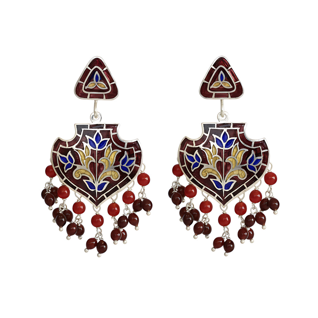Pair of decorative enamel silver earrings with intricate designs in red, gold and blue colours on a white background