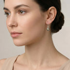 Close-up of a woman wearing a black-gold silver enamel earring against a gray background