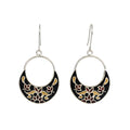 Pair of silver enamel earrings with black and gold floral patterns on a white background