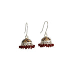 Pair of silver enamel jhumka earrings with red beads on a white background