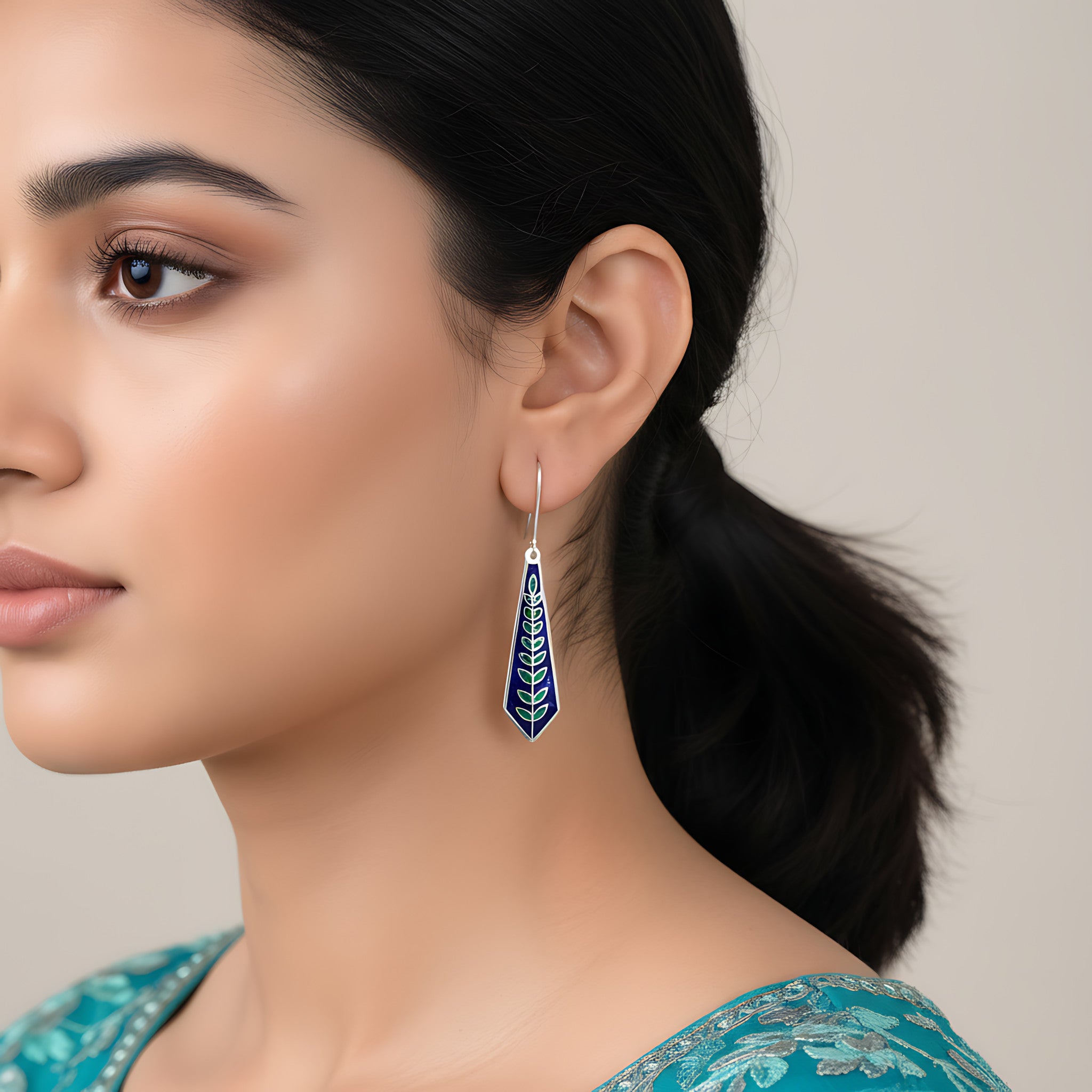 Woman wearing a blue silver enamel earring on a neutral background