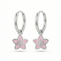 Silver hoop earrings with lavender flower charms on a white background