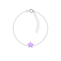 Silver bracelet with a purple flower charm on a white background