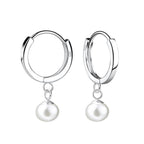 Silver hoop earrings with fresh water pearl drops on a white background