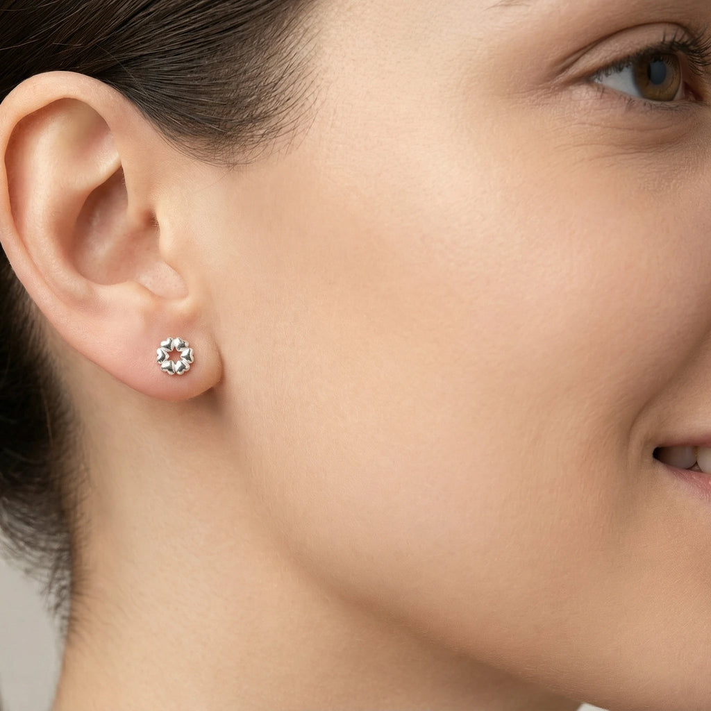 Woman wearing silver heart stud earring with red balloons in the background