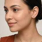 Closeup of a woman wearing a rust colour dress and a hexagon shaped silver stud earring