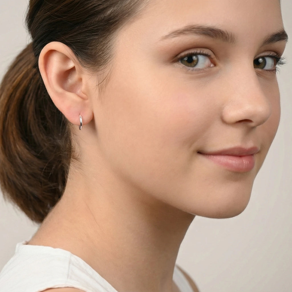 Close-up of a young girl with styled hair and silver hoop earrings against a neutral background