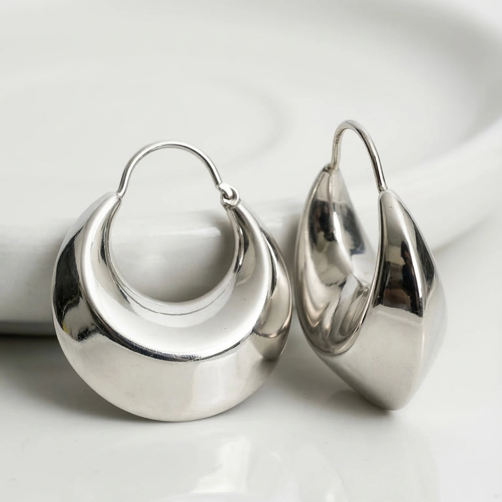 Pair of silver hoop earrings on a white background
