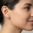 Close-up of a female wearing a crescent moon stud earring with a neutral background
