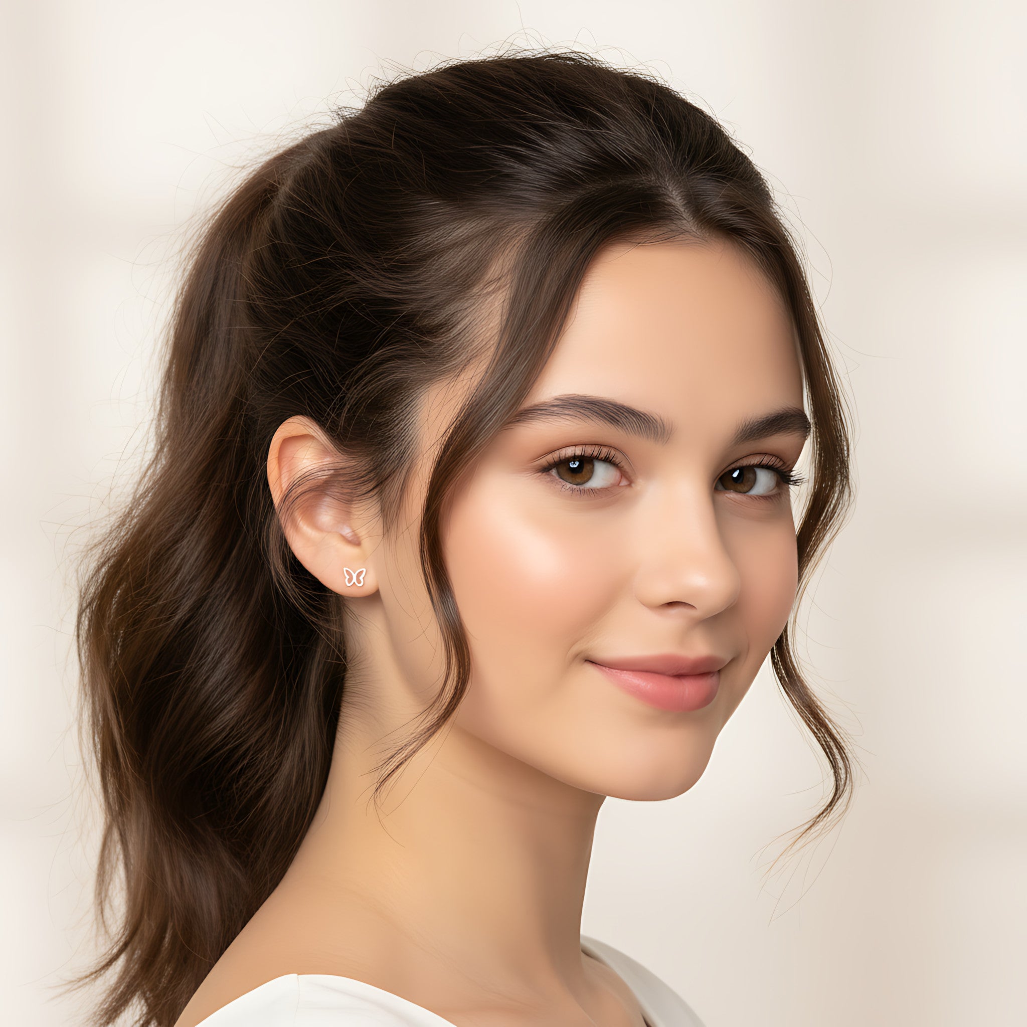 Close-up of a young girl with styled hair and silver butterfly stud earrings against a neutral background