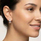 Close-up of a woman wearing a Silver Patterned Geometric French Lock Hoop Earring with a neutral background