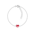Silver bracelet with a red heart-shaped charm on a white background
