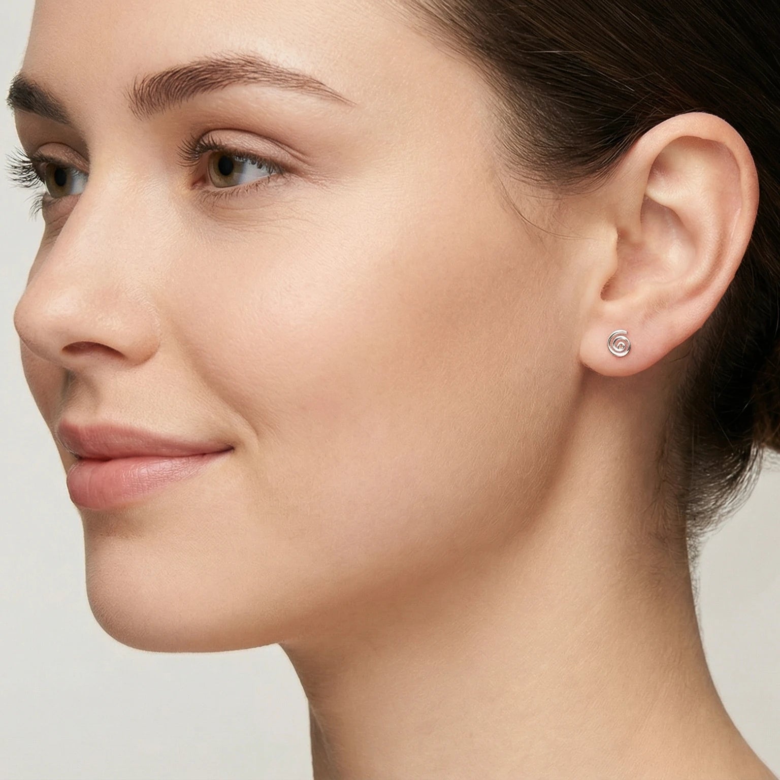 Closeup of a woman wearing a spiral stud earring