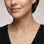 Closeup of a female wearing a silver necklace with a small star pendant against a neutral background