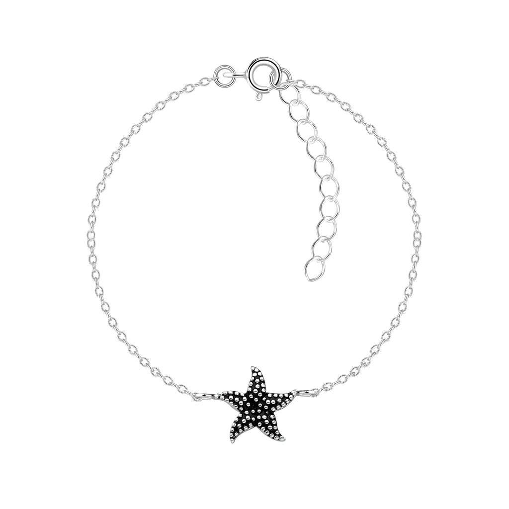 Silver bracelet with a black starfish charm on a white background