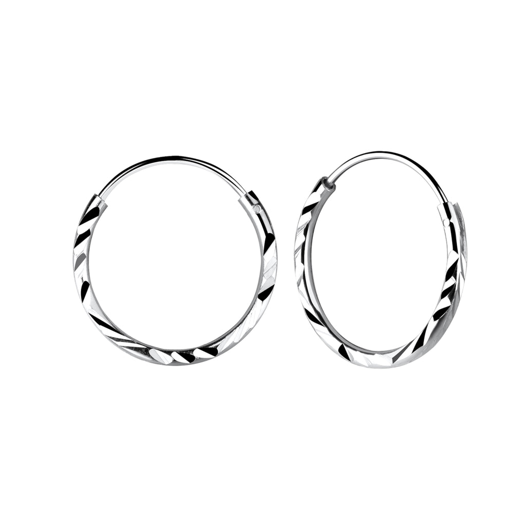 Pair of silver hoop earrings with twisted cut design on a white background