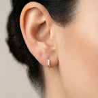Pair of silver hoop earrings with twisted textured look on a white background