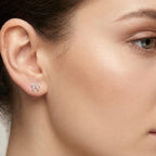 Close-up of a woman wearing twisted bow shape silver stud earring