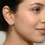 Close-up of a woman wearing Silver Twisted French Lock Hoop Earrings